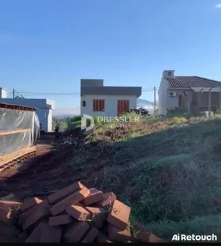 Vista externa de uma propriedade com terra e materiais no primeiro plano.