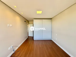 Foto de um corredor interno com piso de madeira e um armário branco.
