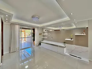 Sala de estar com piso de cerâmica e portas de vidro que dão acesso ao exterior.