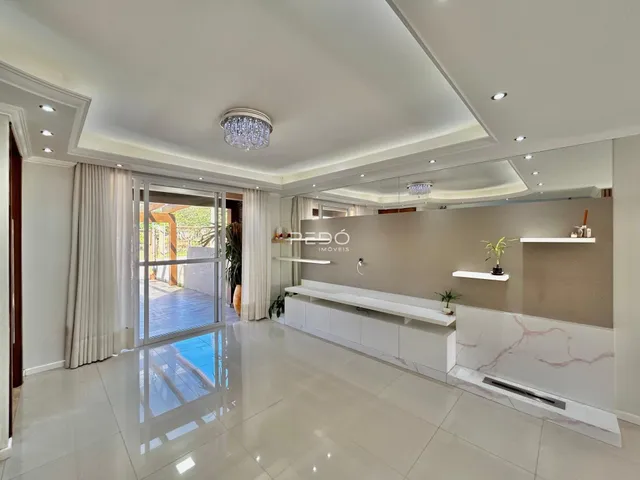 Sala de estar com piso de cerâmica e portas de vidro que dão acesso ao exterior.