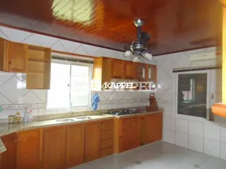 Foto de uma cozinha com armários de madeira e bancada clara.