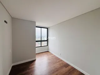 Sala de estar com piso de madeira e vista da paisagem.
