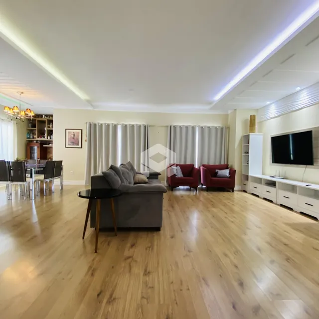 Sala de estar com piso de madeira clara e decoração moderna.