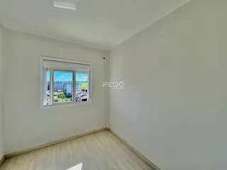 Ambiente interno de uma sala com piso de madeira e janela com vista.