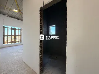 Foto de uma passagem interna com uma janela que oferece uma vista da paisagem urbana.