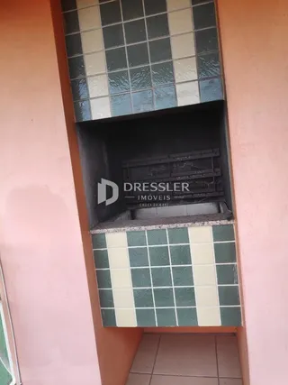 Parede decorada com azulejos verdes e brancos em uma área interna.