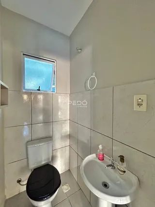 Foto interna de um banheiro com revestimento cerâmico nas paredes e piso.
