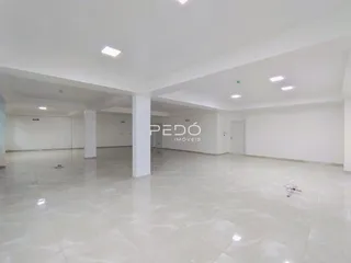 Ambiente interno amplo com piso de cerâmica e paredes brancas.