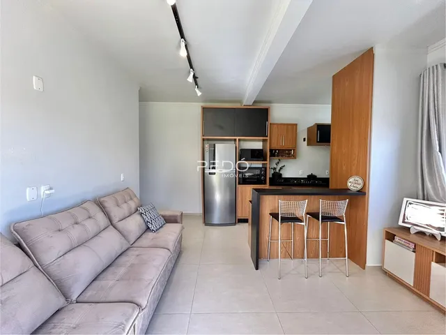 Sala de estar com cozinha integrada em apartamento no Brasil.