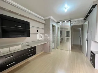 Ambiente interno de uma sala com armários escuros e piso claro.