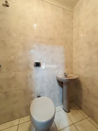Foto do interior de um banheiro com revestimento de azulejos brancos.