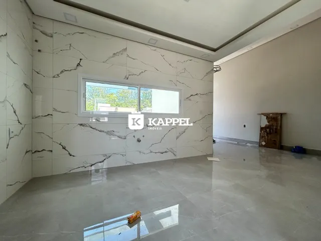 Sala ampla com paredes de mármore branco e uma grande janela.