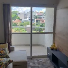 Vista interna de uma sala com portas de vidro que dão acesso a uma área externa.