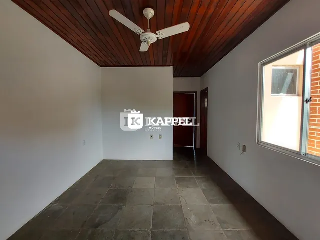 Hall de entrada com piso de pedra escura e forro de madeira.