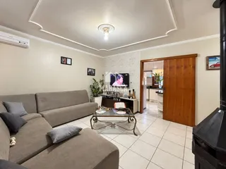 Sala de estar com sofá e piso de cerâmica clara.