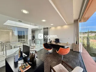 Uma sala de estar moderna com vista panorâmica para a paisagem externa.