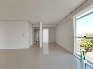 Interior de um espaço amplo com paredes brancas e piso claro.