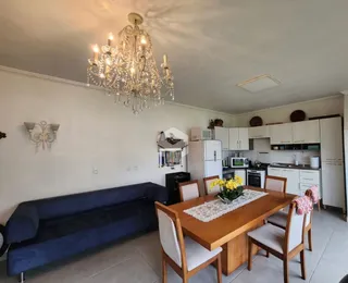 Sala de estar com sofá azul e mesa de jantar de madeira.