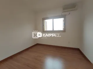 Foto de uma sala de estar com piso de madeira e janela.