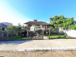 Fachada de uma residência em Lajeado, Brasil, com cerca e vegetação ao redor.