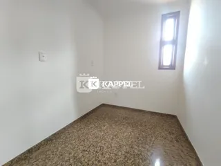 Foto de uma área interna com bancada de granito e paredes brancas.