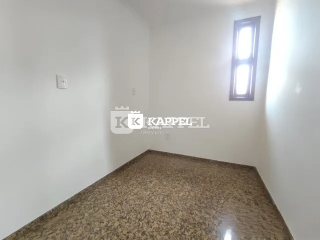 Foto de uma área interna com bancada de granito e paredes brancas.
