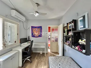 Quarto com escrivaninha e janela em um apartamento.