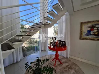 Ambiente interno com escadaria e vista para o exterior.