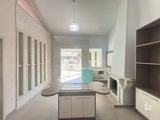Interior de uma sala com piso de madeira e parede texturizada.