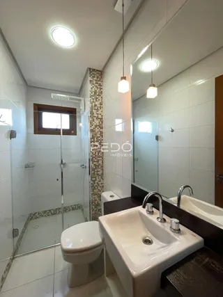 Banheiro com box de vidro e pia.