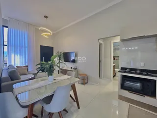 Sala de estar com sofá e mesa de jantar em um apartamento moderno.