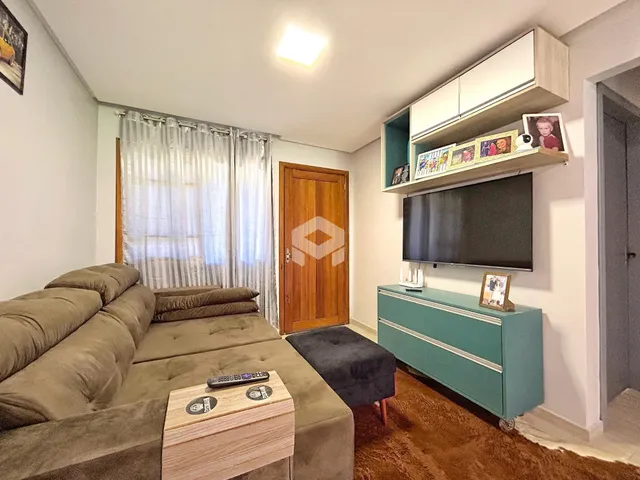 Sala de estar com sofá e televisão em um apartamento.