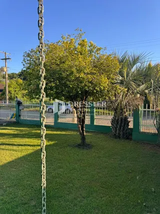Vista externa de um jardim com gramado e cerca em Lajeado.