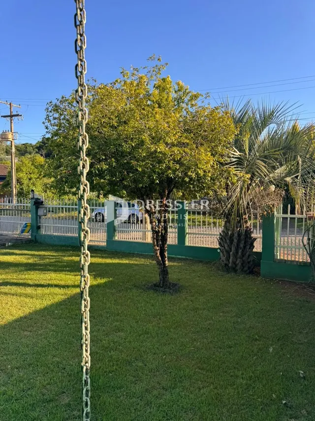 Vista externa de um jardim com gramado e cerca em Lajeado.
