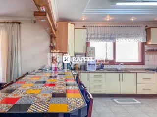 Foto de uma sala de jantar com mesa coberta por um tecido xadrez em um ambiente interno.