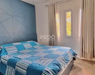 Quarto com cama decorada e janelas com cortinas.