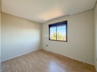 Sala de estar com piso de madeira e janela de grande porte.