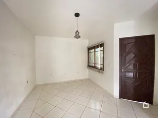 Vista interna de um ambiente com piso de cerâmica e porta de madeira.
