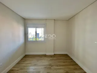 Ambiente interno com piso de madeira clara e paredes brancas.