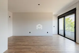 Ambiente interno de uma sala com piso de madeira e porta de vidro.