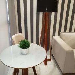 Mesa redonda branca com uma planta verde em um ambiente interno.