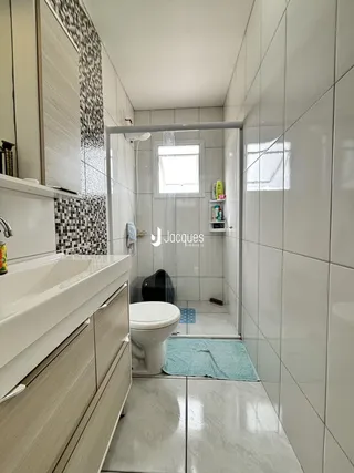 Foto de um banheiro moderno com revestimento cerâmico e piso claro.