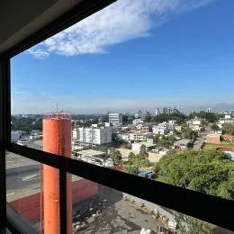 Vista aérea de uma paisagem urbana em Lajeado, Brasil, mostrando edifícios e vegetação.