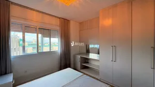 Quarto com grandes janelas e armários embutidos.