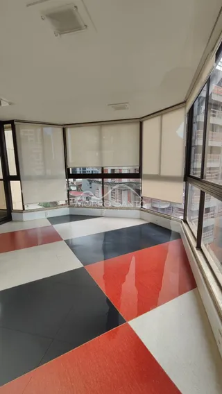 Vista interna de um ambiente com piso colorido e grandes janelas.