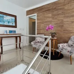 Vista de um ambiente com painel de madeira e grade de metal na área externa.