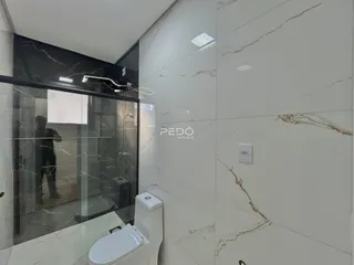 Interior de um banheiro com revestimento em mármore claro.