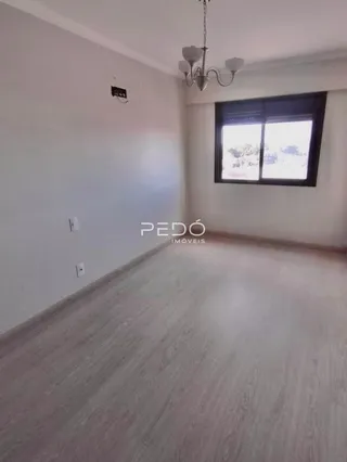 Ambiente interno de uma sala com piso de madeira clara e parede branca.