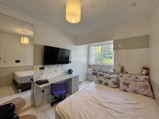 Quarto com cama grande e televisão em um imóvel no Brasil.