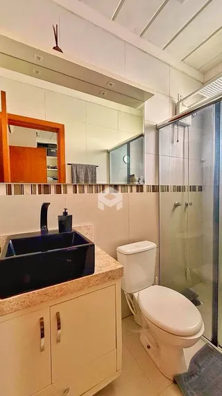 Foto de um banheiro interno com pia e box de vidro.